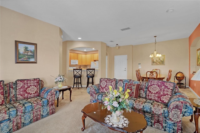 living room featuring a chandelier and light colored carpet