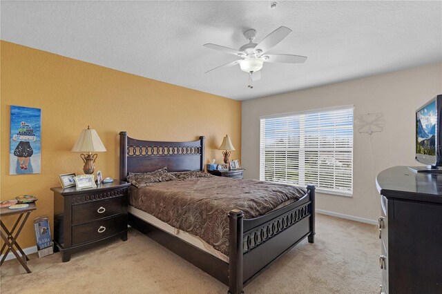 bedroom with light carpet, a textured ceiling, and ceiling fan