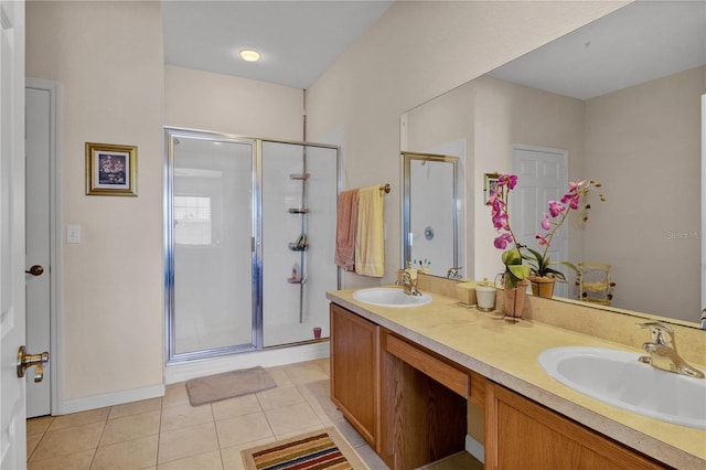 bathroom with a shower with door, double vanity, and tile patterned flooring