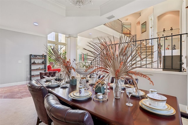 carpeted dining area featuring a chandelier, a tray ceiling, and crown molding