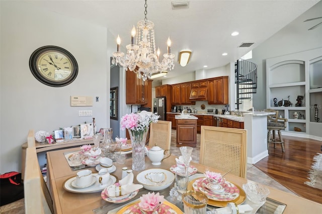 dining space with a chandelier, lofted ceiling, light wood-type flooring, and built in features