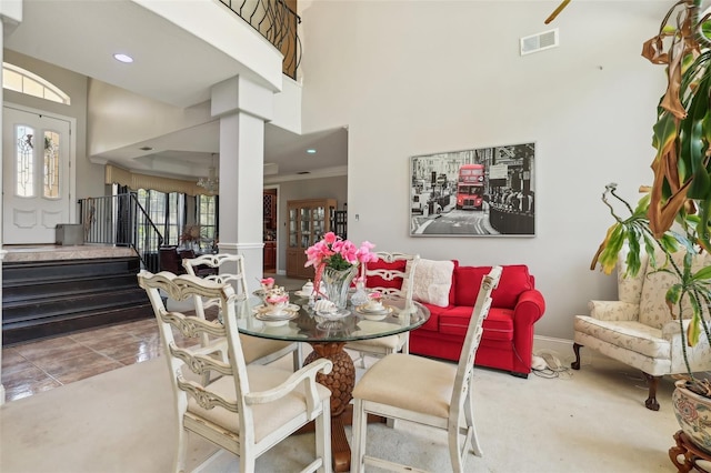 dining room with tile flooring, a high ceiling, and ornamental molding