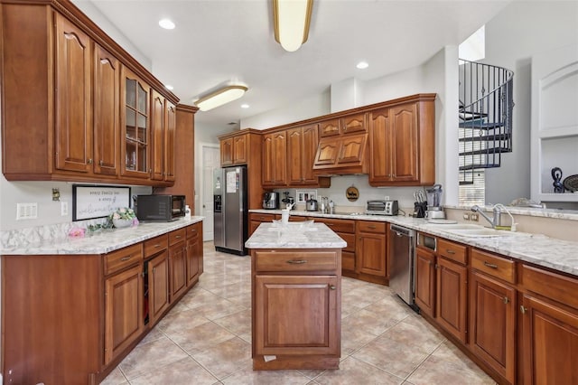 kitchen with a kitchen island, stainless steel appliances, custom exhaust hood, light stone countertops, and light tile floors