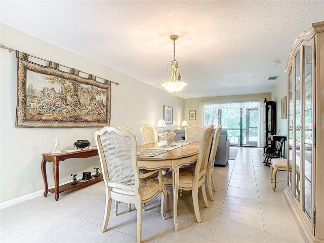 tiled dining space featuring a textured ceiling