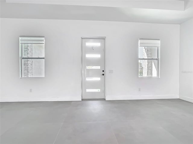 interior space with baseboards and finished concrete flooring