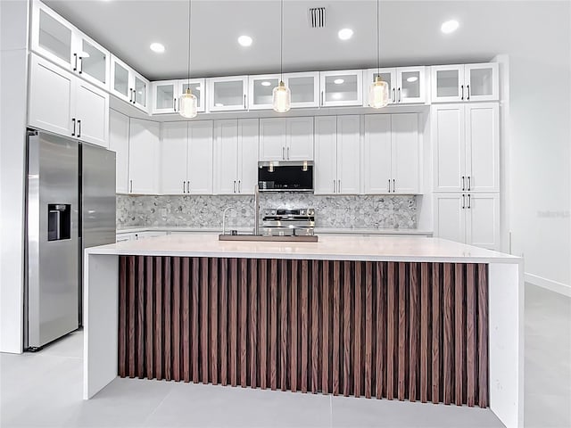 kitchen with light countertops, a spacious island, backsplash, and stainless steel appliances