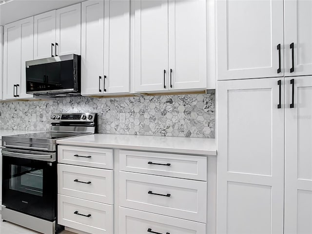 kitchen with white cabinetry, light countertops, backsplash, and stainless steel appliances