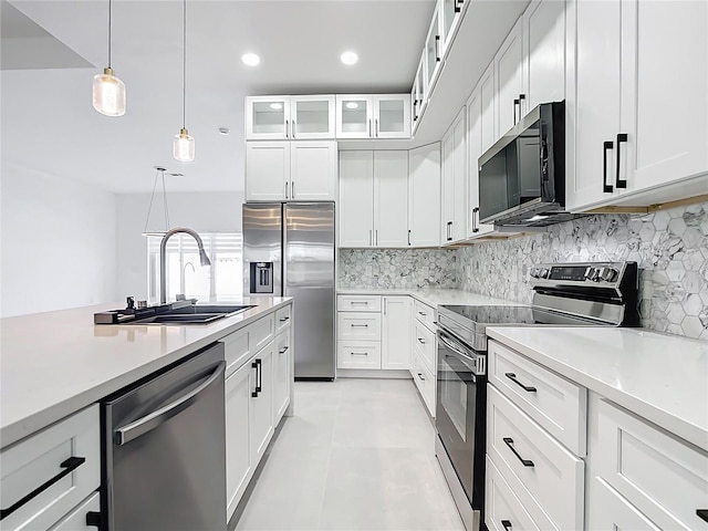 kitchen with tasteful backsplash, stainless steel appliances, light countertops, and a sink