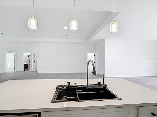 kitchen featuring hanging light fixtures, open floor plan, and a sink