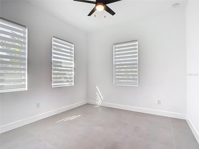 spare room with a healthy amount of sunlight, baseboards, and ceiling fan