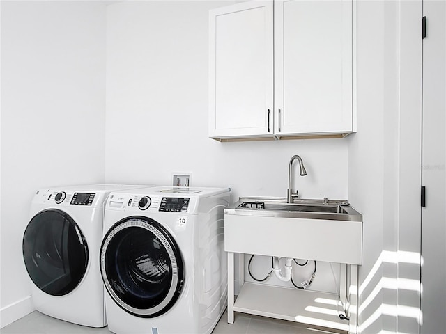 laundry area with a sink, cabinet space, baseboards, and washing machine and clothes dryer