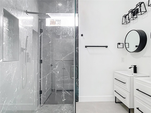 full bath featuring vanity, tile patterned flooring, baseboards, and a marble finish shower