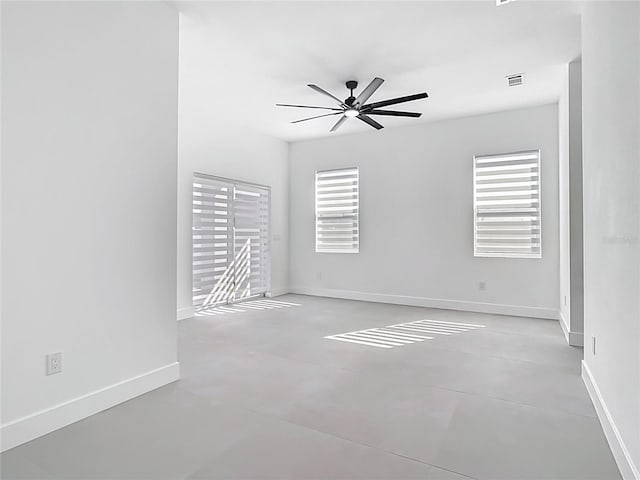 spare room with visible vents, baseboards, concrete floors, and ceiling fan