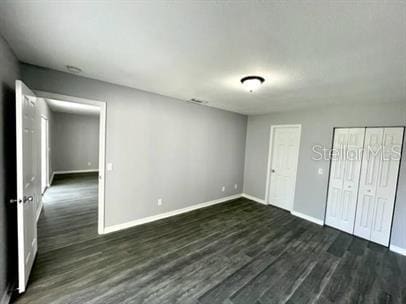 unfurnished bedroom featuring dark hardwood / wood-style flooring