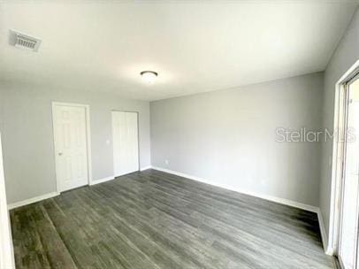 unfurnished bedroom with dark wood-type flooring