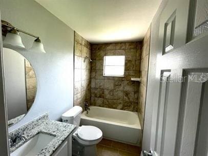 full bathroom featuring tile flooring, vanity, toilet, and tiled shower / bath combo