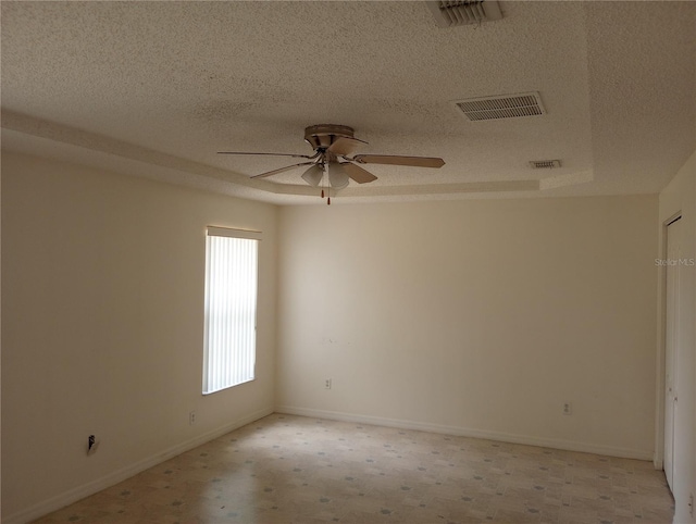 unfurnished room featuring ceiling fan, light colored carpet, and a textured ceiling