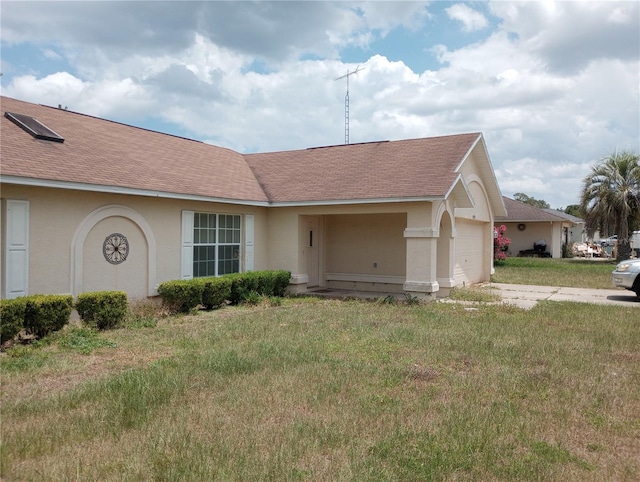 ranch-style home featuring a garage and a front lawn