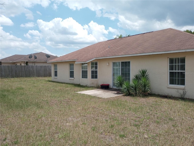 rear view of house with a patio area and a yard