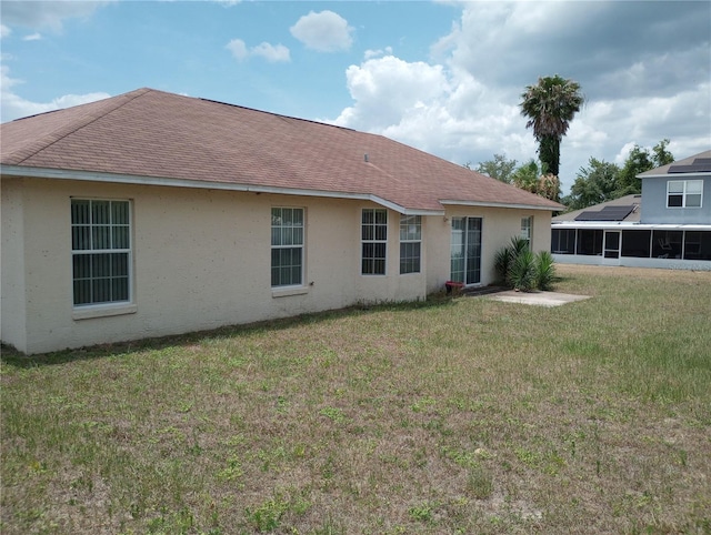 rear view of property featuring a lawn