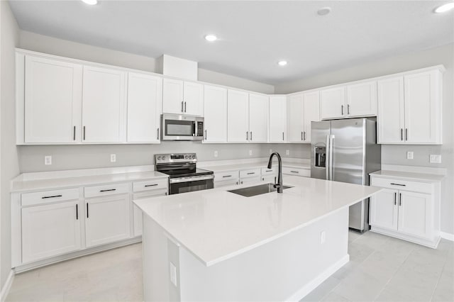 kitchen with white cabinets, an island with sink, and stainless steel appliances