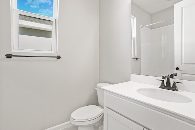 bathroom featuring vanity, toilet, and a shower