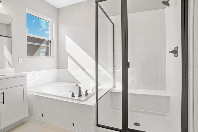 bathroom with tile patterned floors, vanity, and shower with separate bathtub