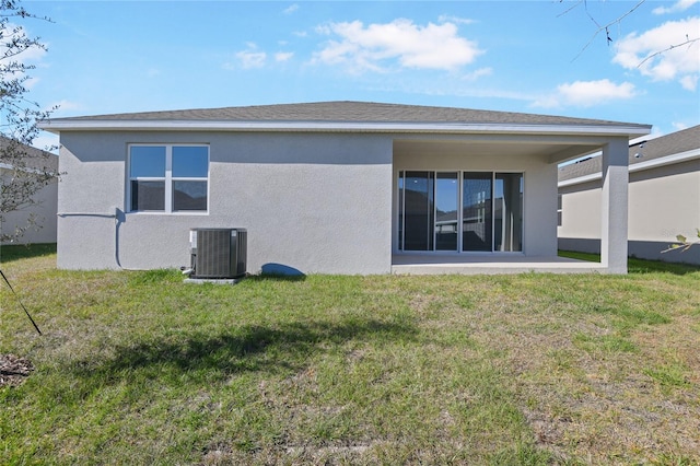 rear view of house with a lawn and central AC