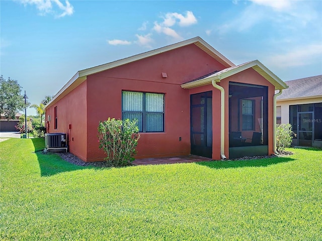 view of front facade featuring a front lawn, a sunroom, and central air condition unit