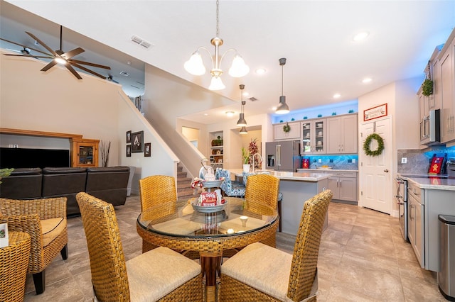 dining area featuring ceiling fan with notable chandelier