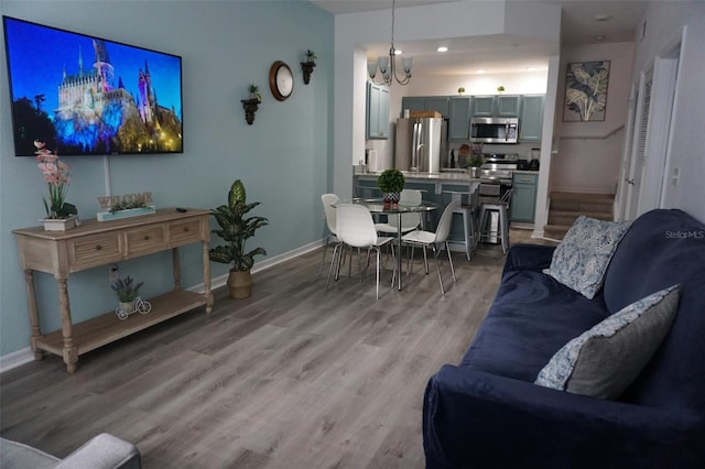 living room with light hardwood / wood-style floors and a chandelier