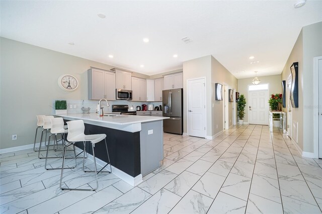 kitchen with a kitchen breakfast bar, kitchen peninsula, sink, and stainless steel appliances