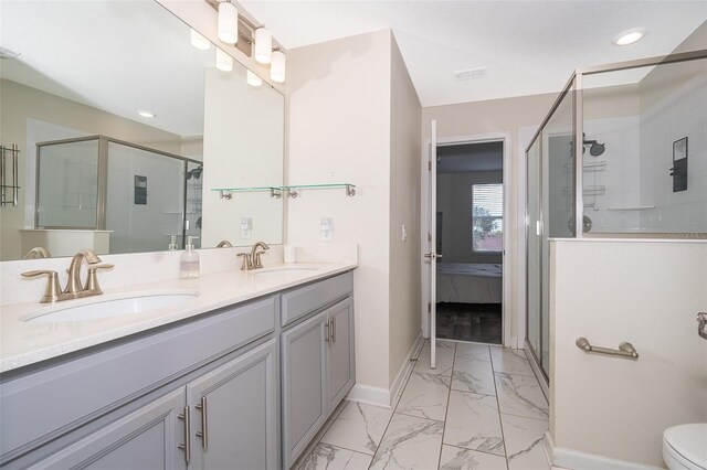 bathroom with vanity, toilet, and a shower with door