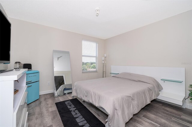 bedroom with dark hardwood / wood-style flooring