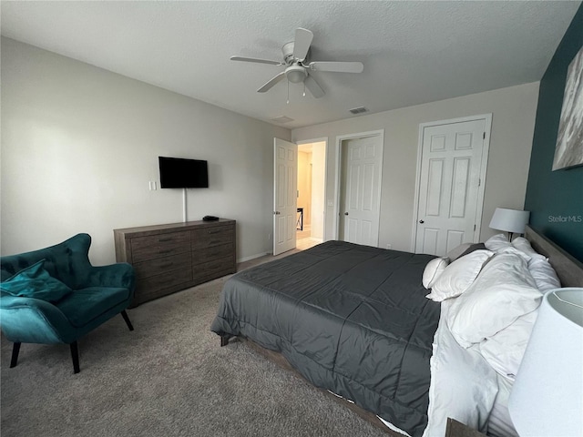 bedroom featuring light carpet, a textured ceiling, and ceiling fan