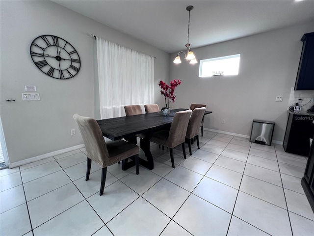 dining space with light tile patterned floors and an inviting chandelier