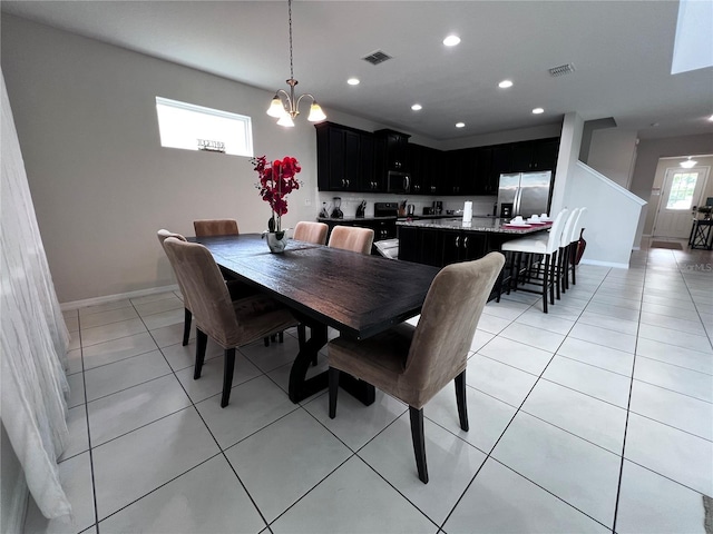 tiled dining space with an inviting chandelier