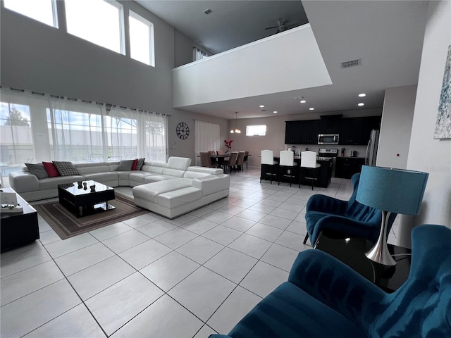 tiled living room with a high ceiling and a notable chandelier