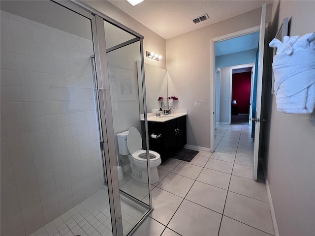 bathroom with tile patterned floors, vanity, an enclosed shower, and toilet