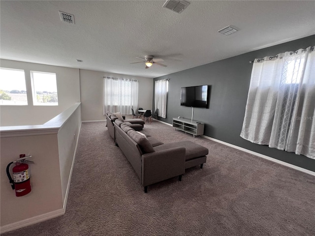 living room featuring carpet, a textured ceiling, and ceiling fan