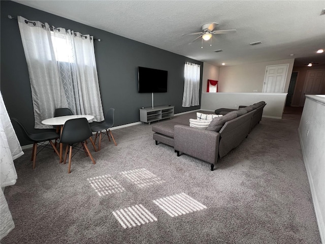 living room with carpet flooring, ceiling fan, and a textured ceiling