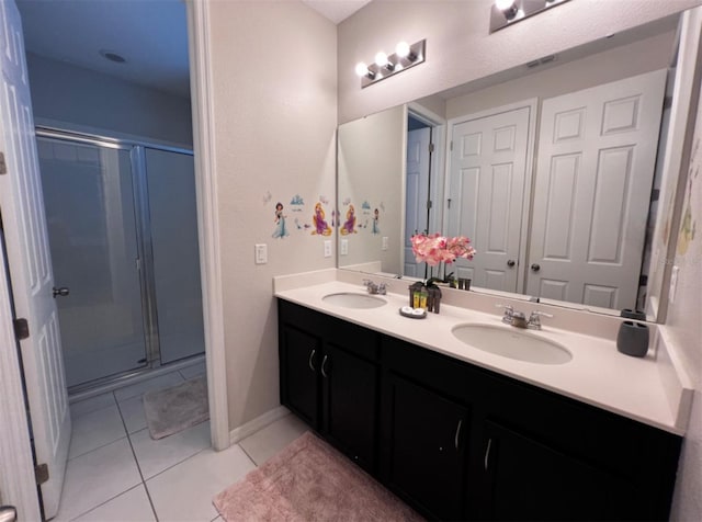 bathroom featuring tile patterned flooring, vanity, and a shower with shower door