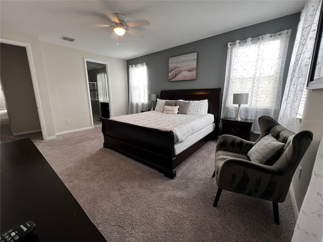 bedroom featuring carpet, ceiling fan, a textured ceiling, and ensuite bath