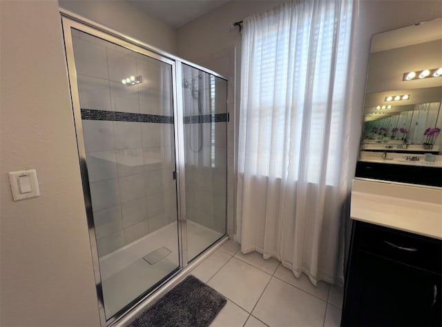 bathroom featuring tile patterned flooring, vanity, and a shower with shower door