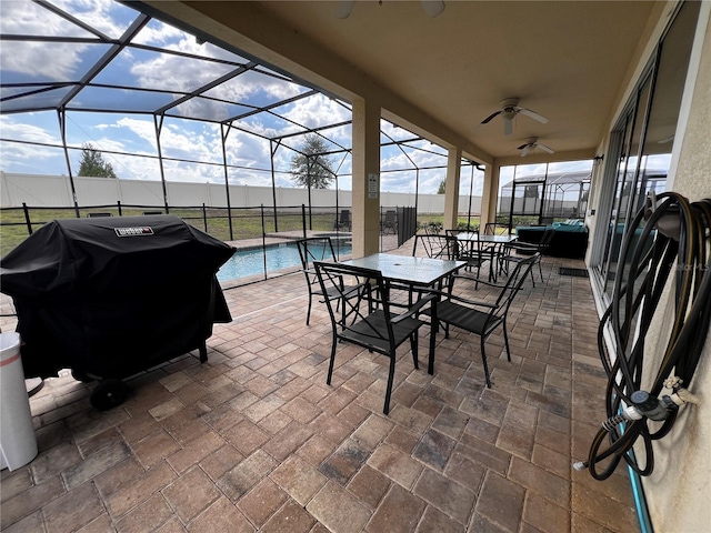 view of patio featuring ceiling fan, a grill, a lanai, and a fenced in pool