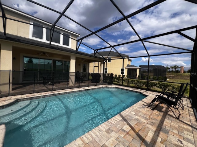 view of swimming pool with ceiling fan, a patio area, and a lanai