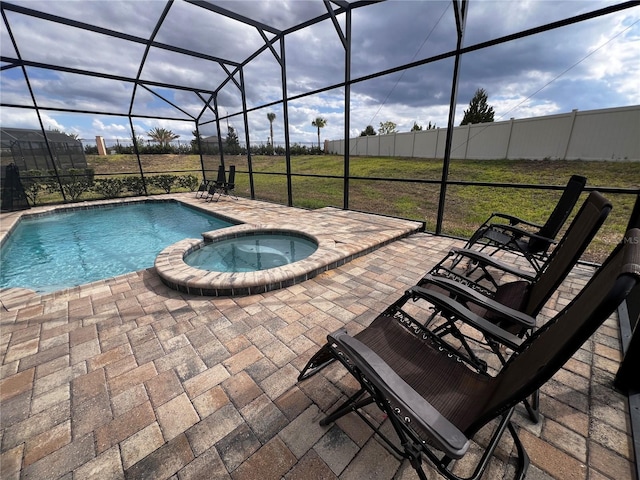 view of pool featuring glass enclosure, an in ground hot tub, a yard, and a patio area