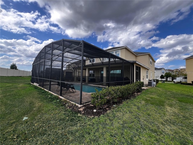 back of house with a yard, a fenced in pool, glass enclosure, and a patio area