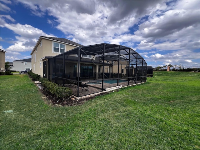 rear view of property featuring a yard and glass enclosure