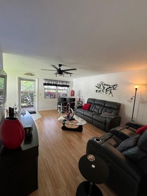 living room featuring ceiling fan and wood-type flooring